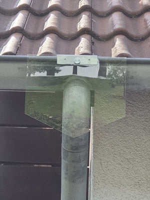 Das Bild zeigt eine transparente Mardersperre, die an einem Fallrohr unterhalb der Dachrinne befestigt ist. Diese Schutzvorrichtung verhindert, dass Marder, Katzen oder andere Tiere am Rohr hochklettern und so Zugang zum Dach oder Dachboden finden. Die Lösung ist unauffällig, wetterbeständig und einfach zu montieren. Ideal für Hausbesitzer, die ihr Gebäude zuverlässig vor Schäden durch Marder oder andere unerwünschte Tiere schützen möchten.