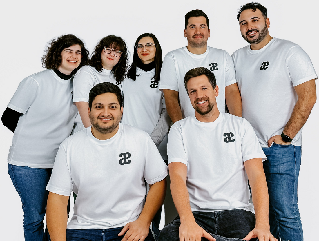 Gruppenfoto eines Teams in weißen T-Shirts mit Kaeferling pro Logo-Aufdruck vor neutralem Hintergrund. Darstellung für Unternehmenswebseite, Teamvorstellung oder Firmenprofil.