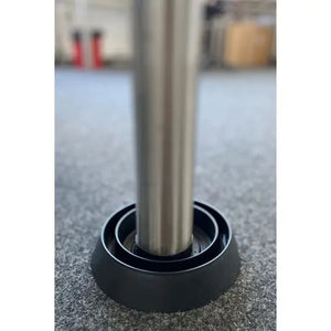 Das Bild zeigt ein Metallmöbelbein, das in einer schwarzen Bettwanzen-Falle auf Teppichboden platziert ist. Diese Falle verhindert, dass Bettwanzen unbemerkt Möbelstücke erklimmen können, und dient gleichzeitig als Monitoring-System. Sie ist eine einfache, diskrete und kostengünstige Methode zur Vorbeugung und Früherkennung von Bettwanzenbefällen – geeignet für Privathaushalte, Hotels, Büros und Gemeinschaftseinrichtungen.